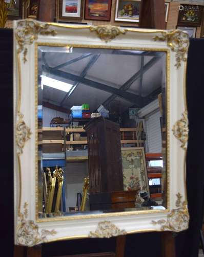 A large antique plaster and wood framed mirror with gilt flo...