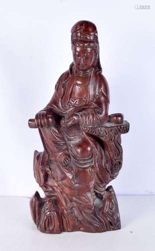 A large Chinese hardwood figure of Guanyin, seated upon a ro...