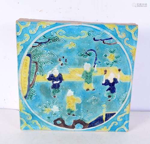 A Chinese turquoise glazed pottery tile, decorated with boys...