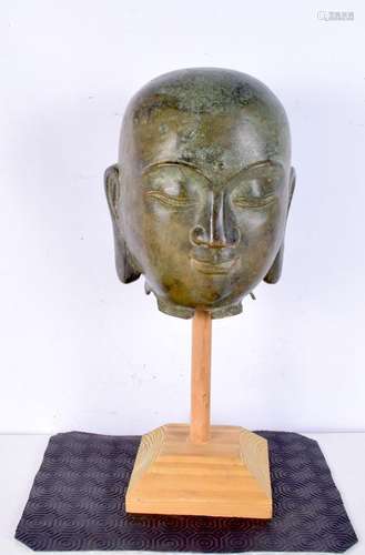 A Tibetan bronze head of buddha, modelled upon a wooden stan...