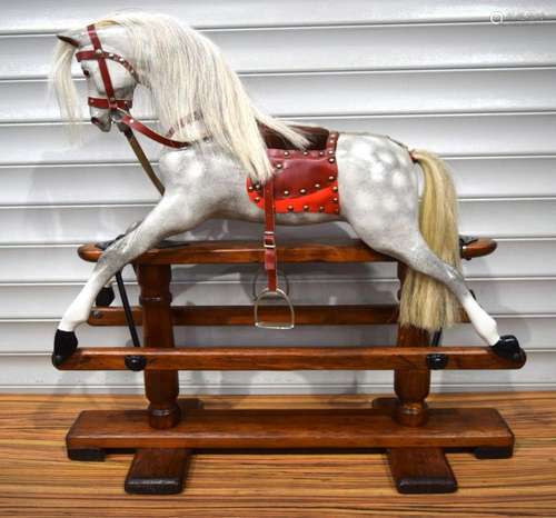 An Edwardian wooden rocking horse 90 x 93 cm .