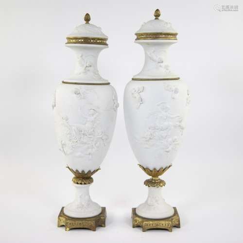 Pair of white biscuit vases with relief decor of putti and g...
