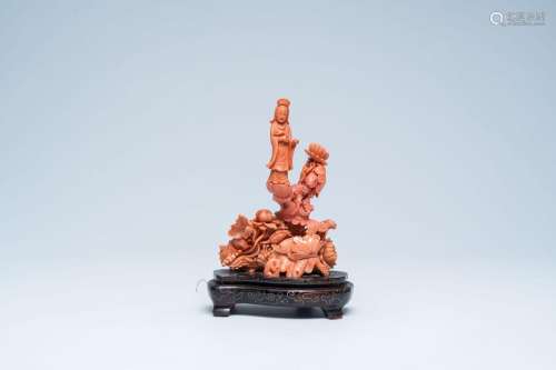 A Chinese red coral figure of a Guanyin standing in a lotus ...