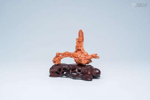A Chinese red coral figure of a Guanyin seated on a lotus th...