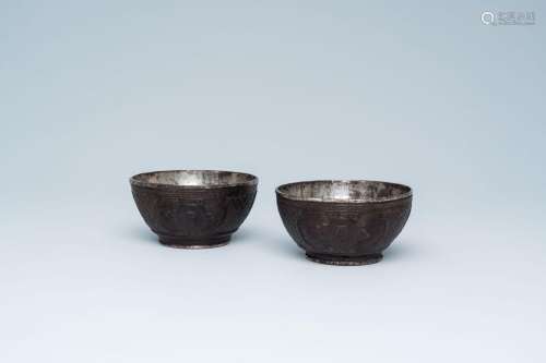 A pair of Chinese engraved coconut bowls with silvered coppe...