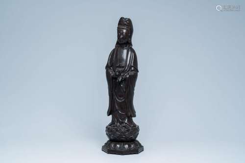 A large Chinese bronze sculpture of Guanyin standing on a lo...