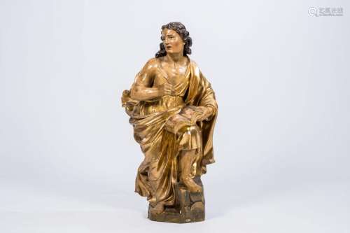 A large gilt and polychrome wooden sculpture of an evangelis...