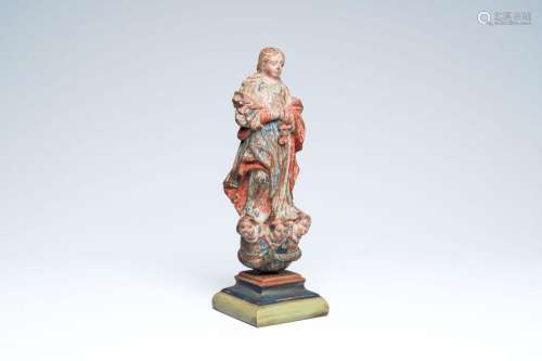 A carved and polychrome painted wood Virgin Mary standing on...