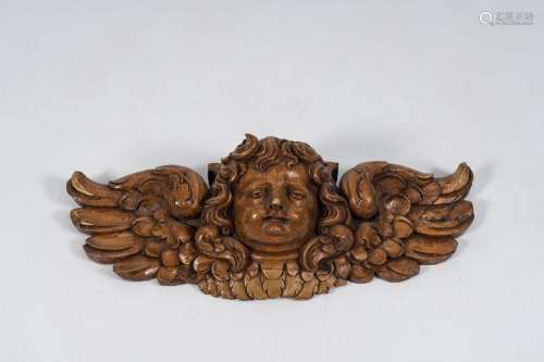 A carved wood angel head, 19th C.<br />
H 24,3 - W 70 cm<br ...