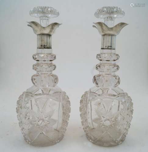 A pair of cut glass decanters and stoppers with silver colla...