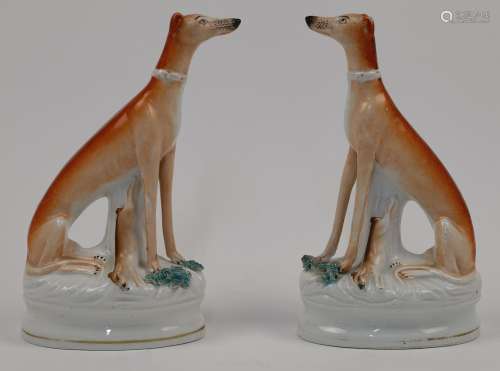 A pair of Staffordshire greyhounds, 19th century, with ochre...