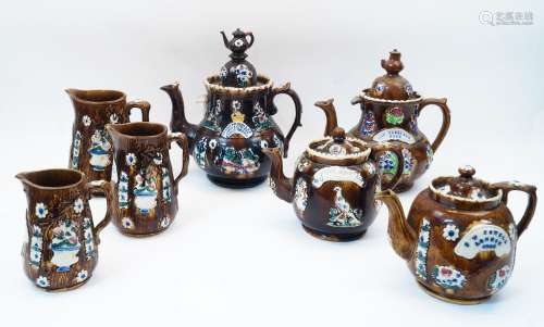 A collection of Victorian Bargeware teapots and jugs, compri...
