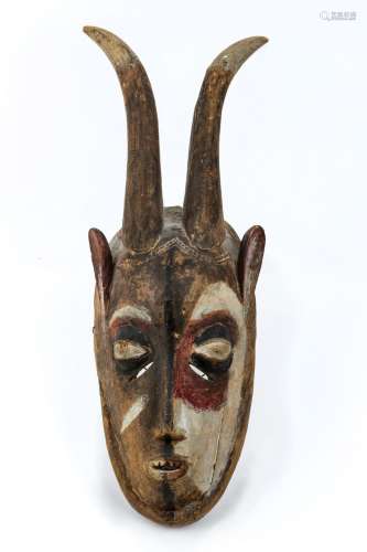 A West African carved wooden mask, polychrome painted, with ...