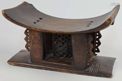 An Ashanti carved wood headrest, with curved top above centr...