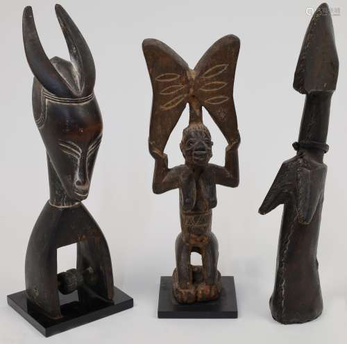 Three African figures, to include a Guro heddle pulley with ...