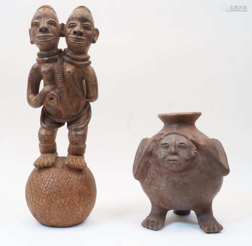 A Nigerian terracotta figure with two heads stood atop a bal...