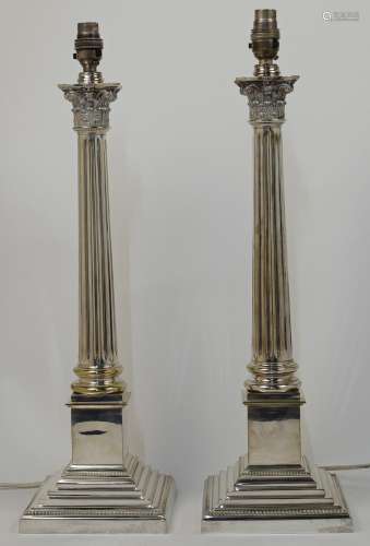 A pair of silver plated Corinthian column table lamps, on sq...
