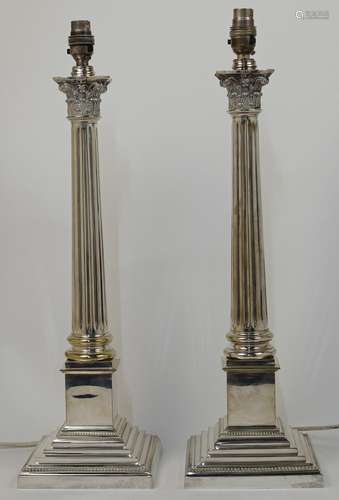 A pair of silver plated Corinthian column table lamps, on sq...