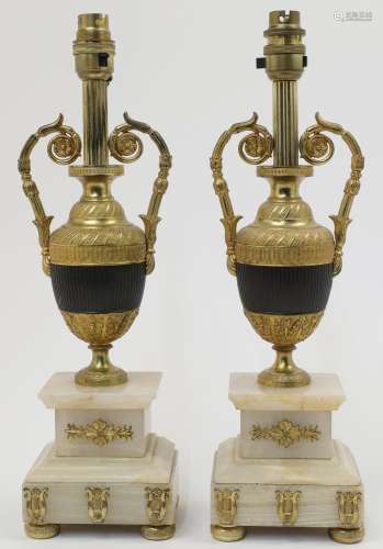 A pair of gilt metal urn shaped table lamps, with bands of r...