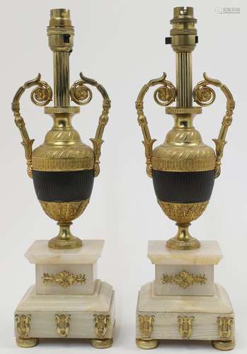 A pair of gilt metal urn shaped table lamps, with bands of r...