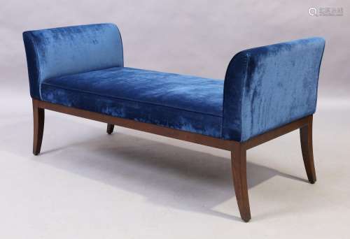 A contemporary window seat, with blue velour upholstery, rai...