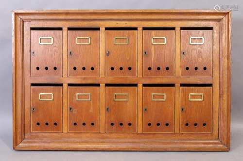 An oak wall mounted bank of ten post boxes, mid 20th century...