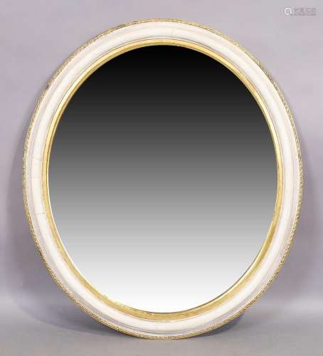 An oval white painted and parcel gilt mirror, early 20th cen...