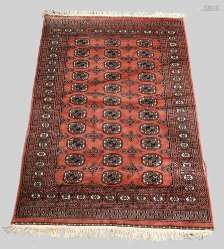 A Bokhara rug, repeating gull motifs, on a salmon pink groun...