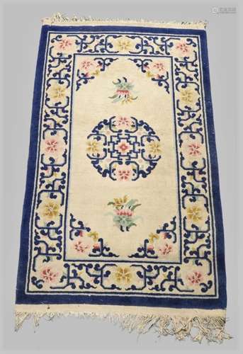 A Chinese woollen rug, mid 20th century, floral design on a ...