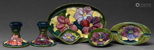 A pair of Moorcroft Clematis candlesticks, three dishes and ...
