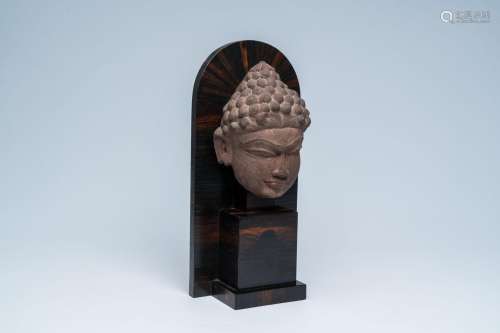 A Southeast Asian stone head of Buddha, probably 17th C.<br ...
