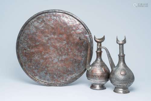 A pair of Islamic tinned copper ewers and a large dish, 19th...