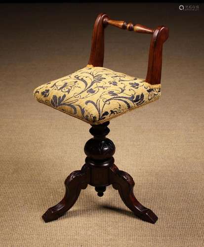 A Carved Mahogany Musician's Stool. The revolving padded...