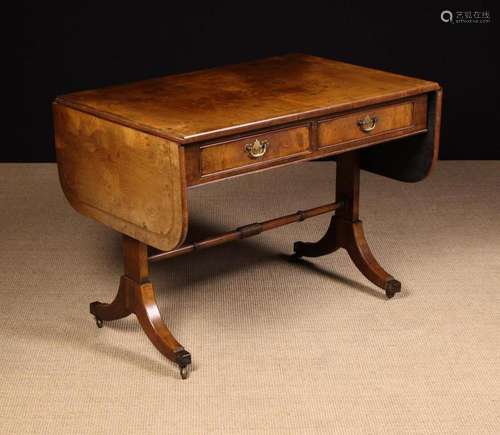 A Figured Walnut Sofa Table inlaid with feather banding. The...