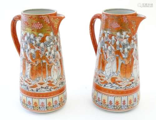 A pair of Japanese Kutani jugs decorated with a crowd of sch...