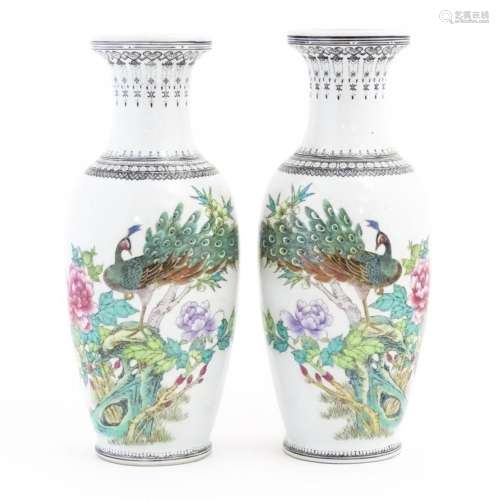 A pair of Chinese vases, each decorated with a peacock perch...