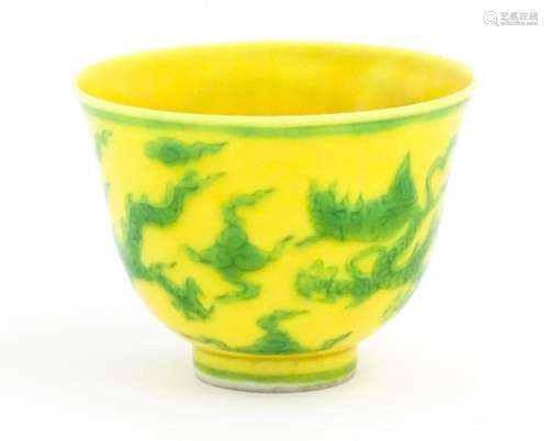 A Chinese wine cup the yellow ground decorated with green dr...
