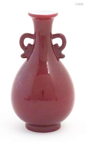 A Chinese vase with shaped twin handles and a red / pink gro...