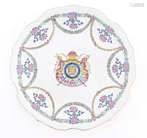 A Chinese style armorial plate with crest to centre and swag...