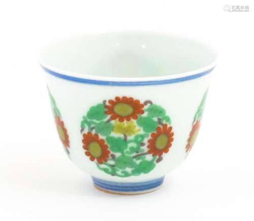 A Chinese wine cup decorated with floral roundels. Character...