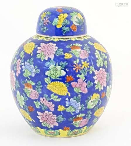 A Chinese ginger jar with a blue ground decorated with flowe...