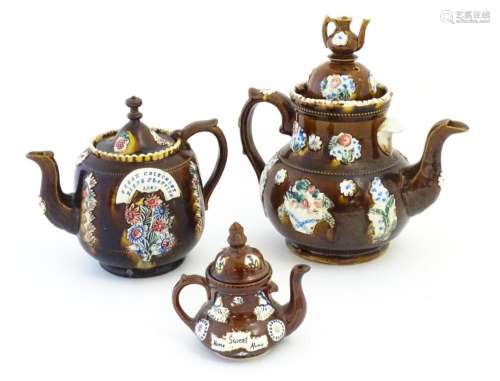 Three Victorian treacle glazed bargeware teapots. with appli...