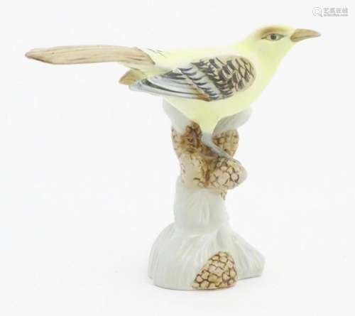 A Royal Dux model of a yellow bird perched on a branch with ...