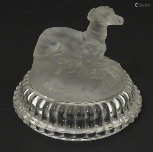A frosted glass model of a greyhound dog upon a lid formed b...