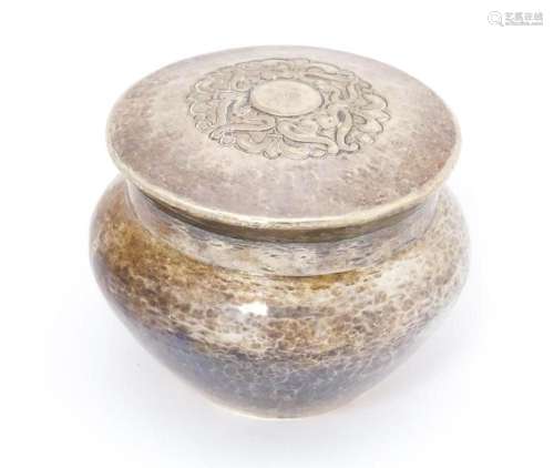 A silver pot and cover with hammered decoration. Hallmarked ...