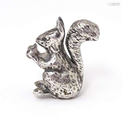 A miniature silver model of a seated squirrel with a nut, ha...