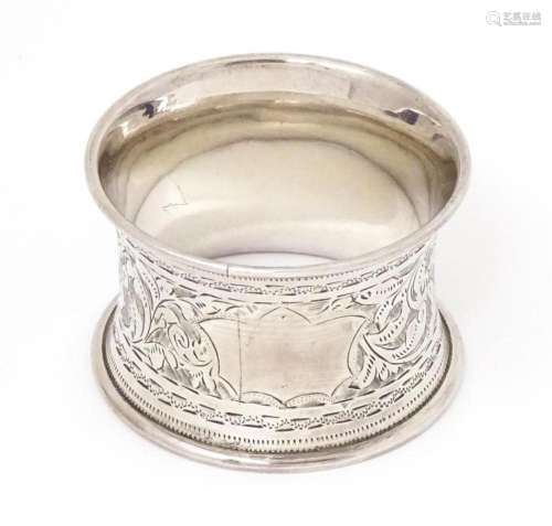 A silver napkin ring with engraved acanthus scroll decoratio...