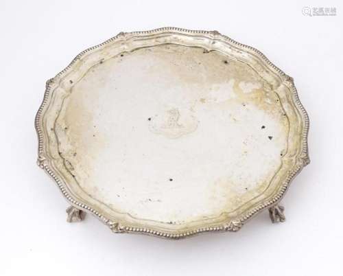 A silver card tray / small salver raised on four ball and cl...