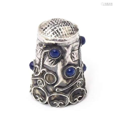 A white metal thimble with blue cabochon detail. 1" hig...