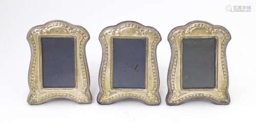 A set of three photograph frames with easel backs and silver...